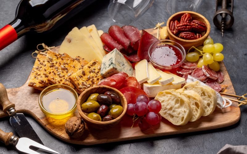 Antipasto board with prosciutto, salami, crackers, cheese, olives and nuts