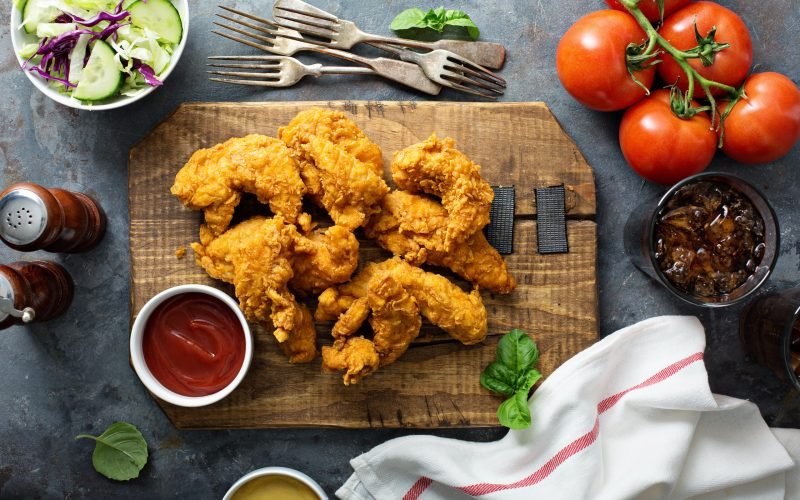 Breaded chicken tenders with ketchup, salad and soda